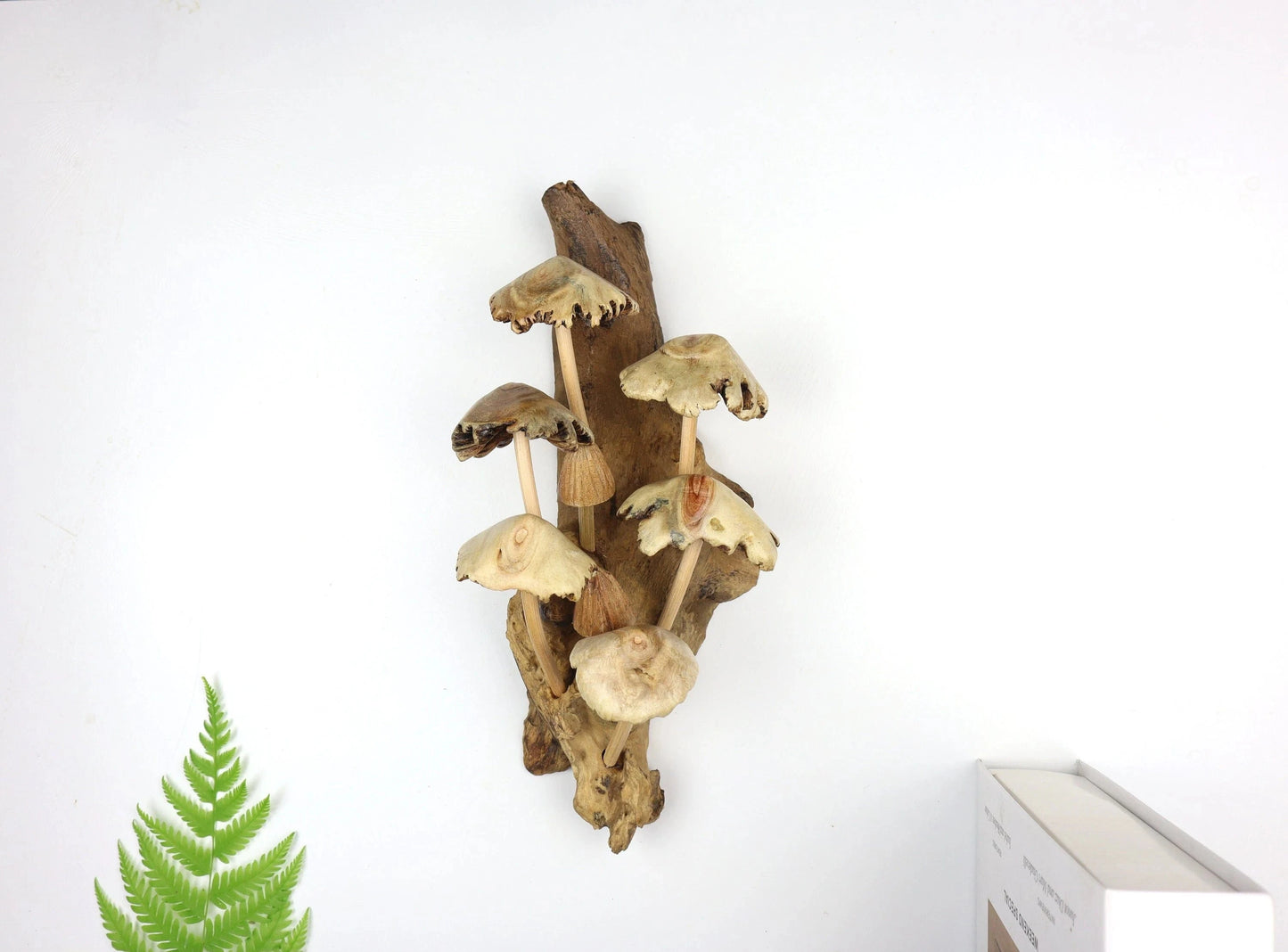 Hand-carved natural wooden sculpture featuring multiple mushrooms with varied caps sprouting vertically from a wood log or root, rustic woodland decor.