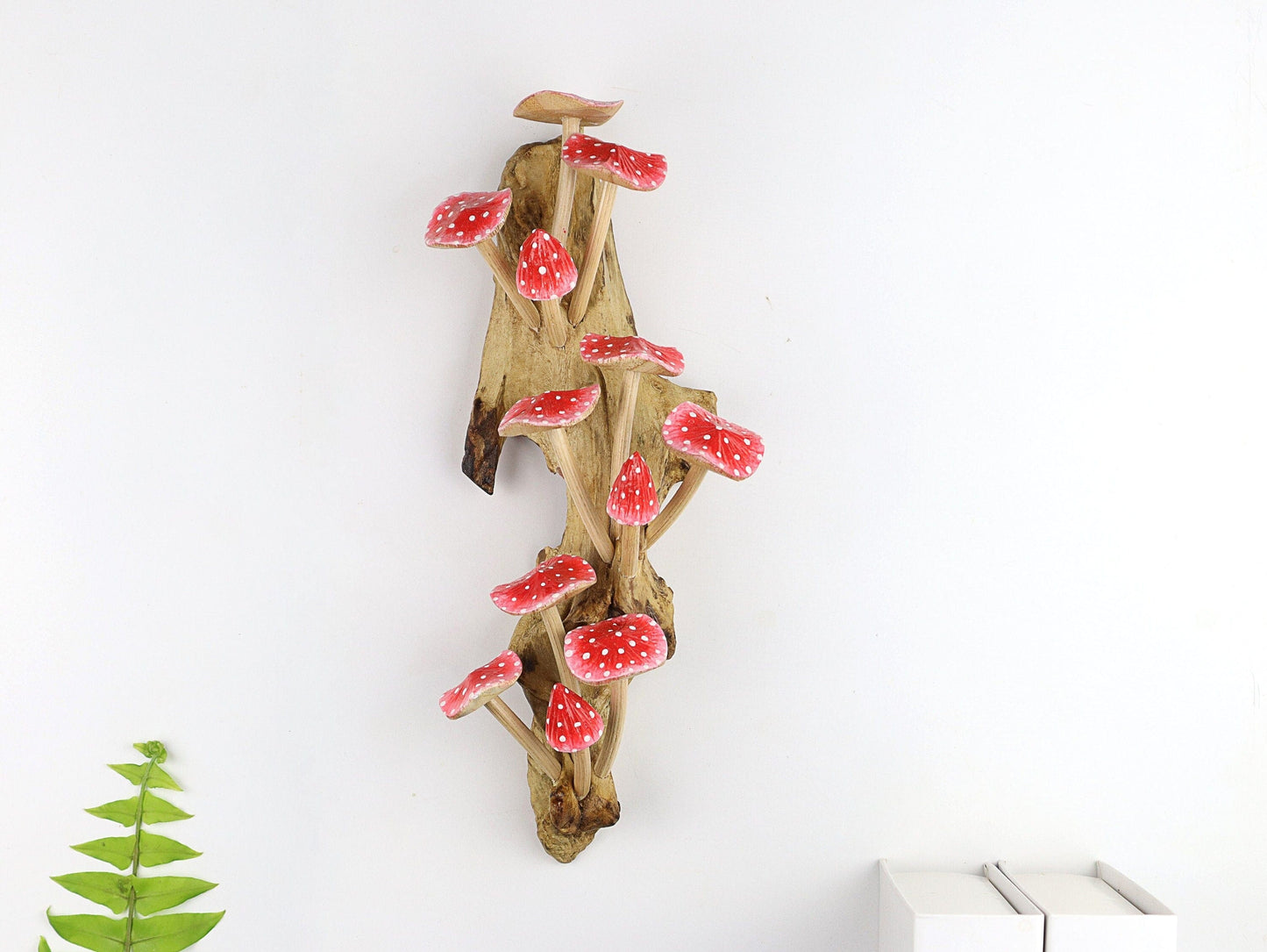 Large hand-carved natural wooden wall art featuring a dense cluster of red and white polka-dot mushrooms on a tall upright natural wood log or root, whimsical fairy tale decor.