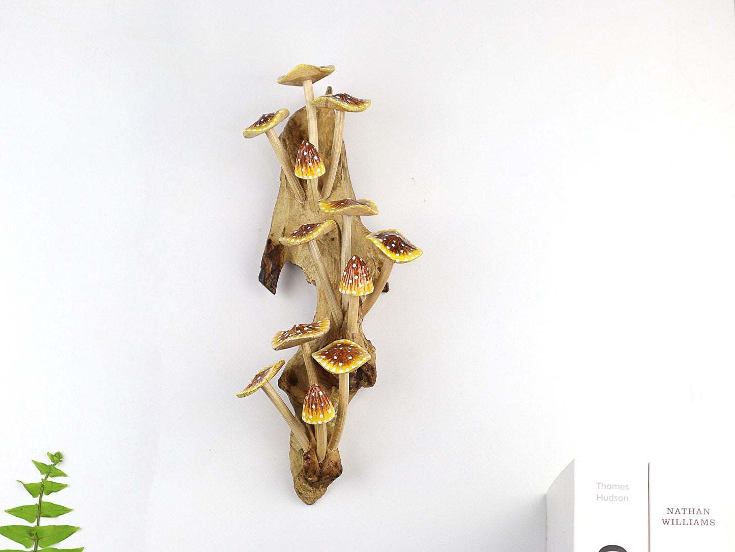 Hand-carved natural wooden sculpture featuring a large cluster of yellow, orange, and red speckled mushrooms on an upright natural wood log or root, whimsical wall art decor.