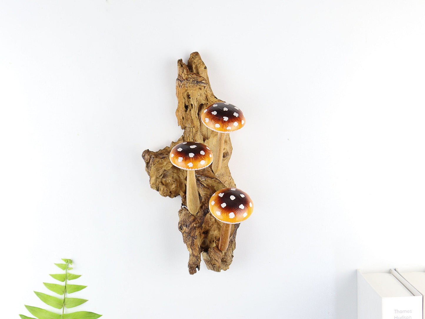 Hand-carved natural wooden wall art featuring three brown and orange polka-dot mushrooms on an upright natural wood log or root, rustic fairy tale decor.