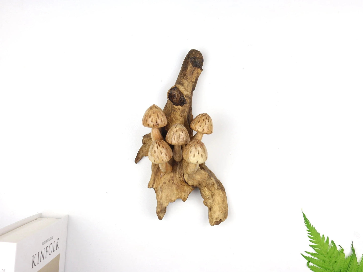 Hand-carved natural wooden sculpture featuring five mushrooms with speckled caps sprouting horizontally from a textured wood log or root, rustic tabletop decor.