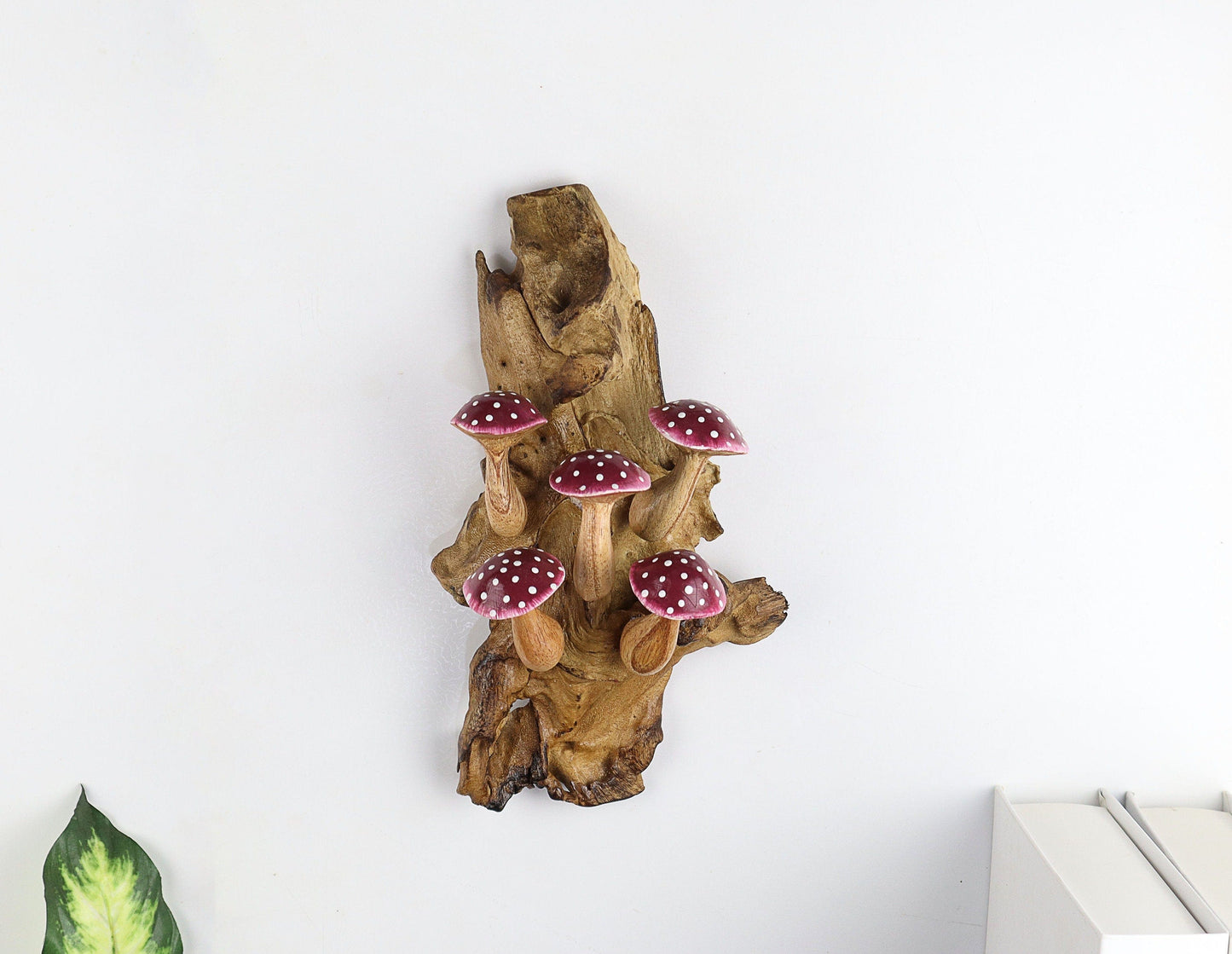 Hand-carved natural wooden wall art featuring six purple and white polka-dot mushrooms on an upright natural wood log or root, whimsical fairy tale decor.