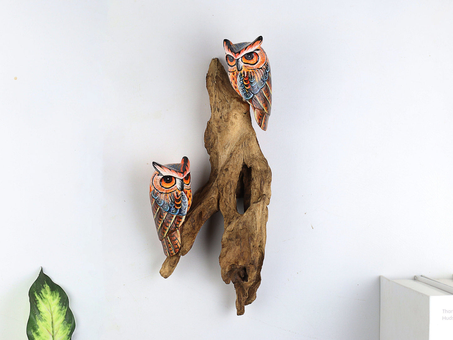 Hand-carved and hand-painted wooden wall art featuring two vibrant owls with orange and blue feathers, perched on a textured natural wood log, rustic folk art decor.