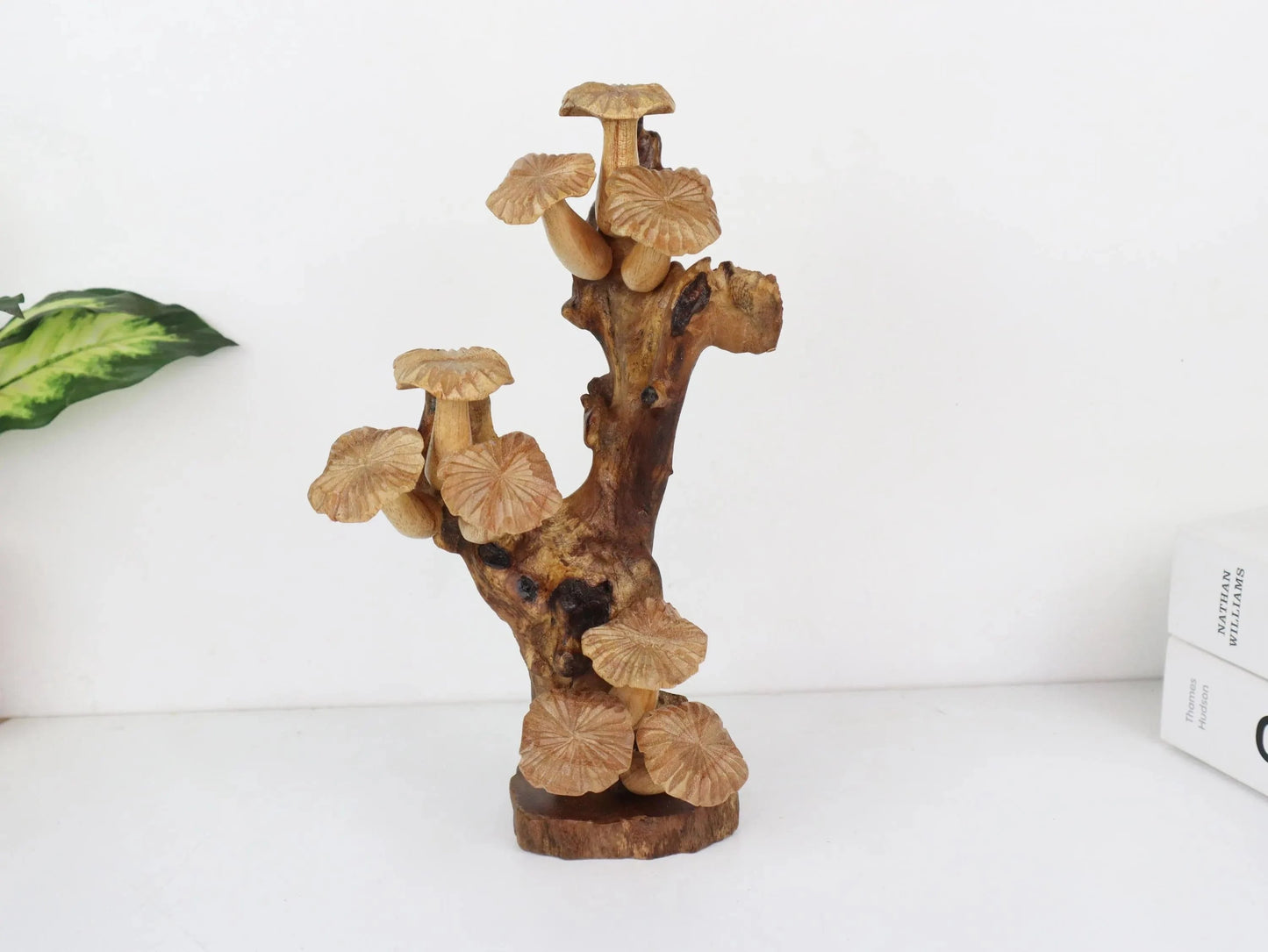 Hand-carved natural wooden sculpture featuring a dense cluster of mushrooms on an upright gnarled wood root, mounted on a round freestanding wooden base, rustic tabletop decor.