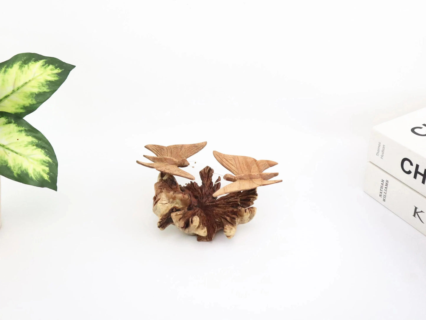 Hand-carved natural wooden sculpture featuring a pair of butterflies facing each other on a gnarled horizontal wood piece, rustic tabletop decor.