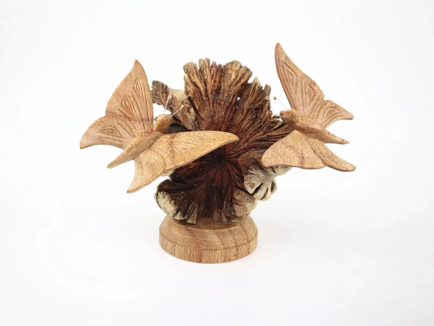 Hand-carved natural wooden sculpture featuring a pair of butterflies on a textured pine cone, mounted on a round freestanding wooden base, rustic insect decor.