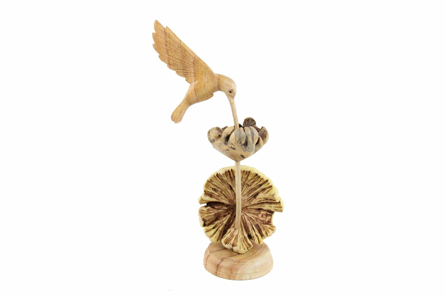 Hand-carved natural wooden sculpture featuring a single hummingbird feeding from a textured wood flower or seed pod, mounted on a round freestanding wooden base, rustic bird decor.