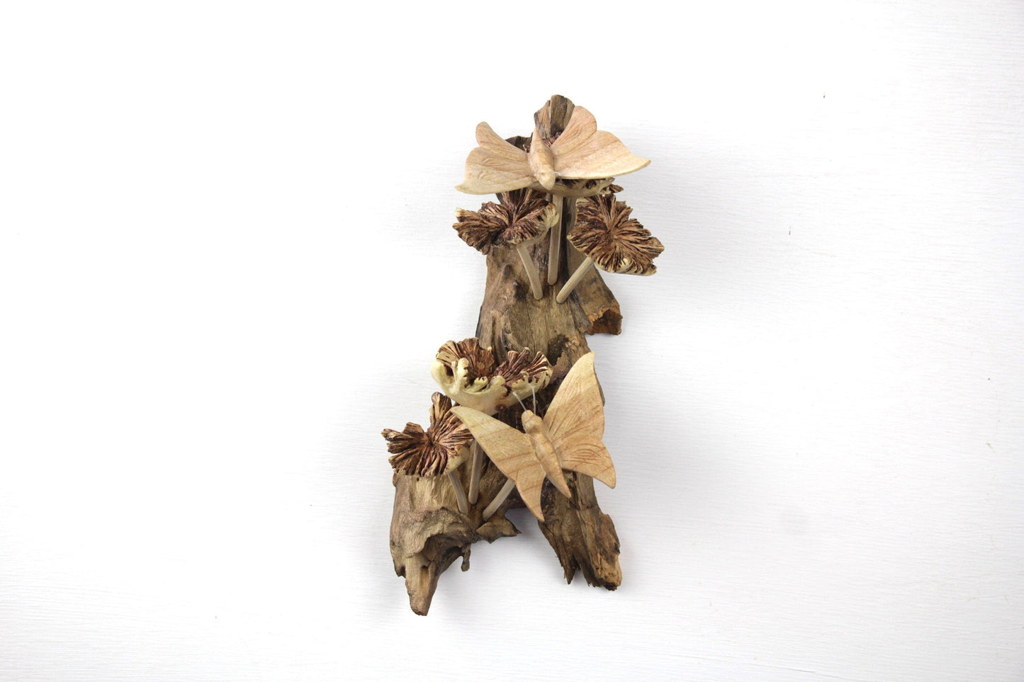 Hand-carved natural wooden wall art featuring two butterflies interacting with flower-like pods on an upright gnarled wood log, rustic garden decor.