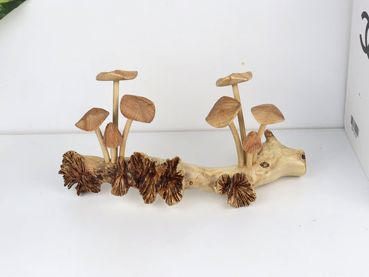 Hand-carved natural wooden sculpture featuring multiple fanned and pleated mushrooms growing horizontally on a long, textured wood log or root, rustic tabletop decor.