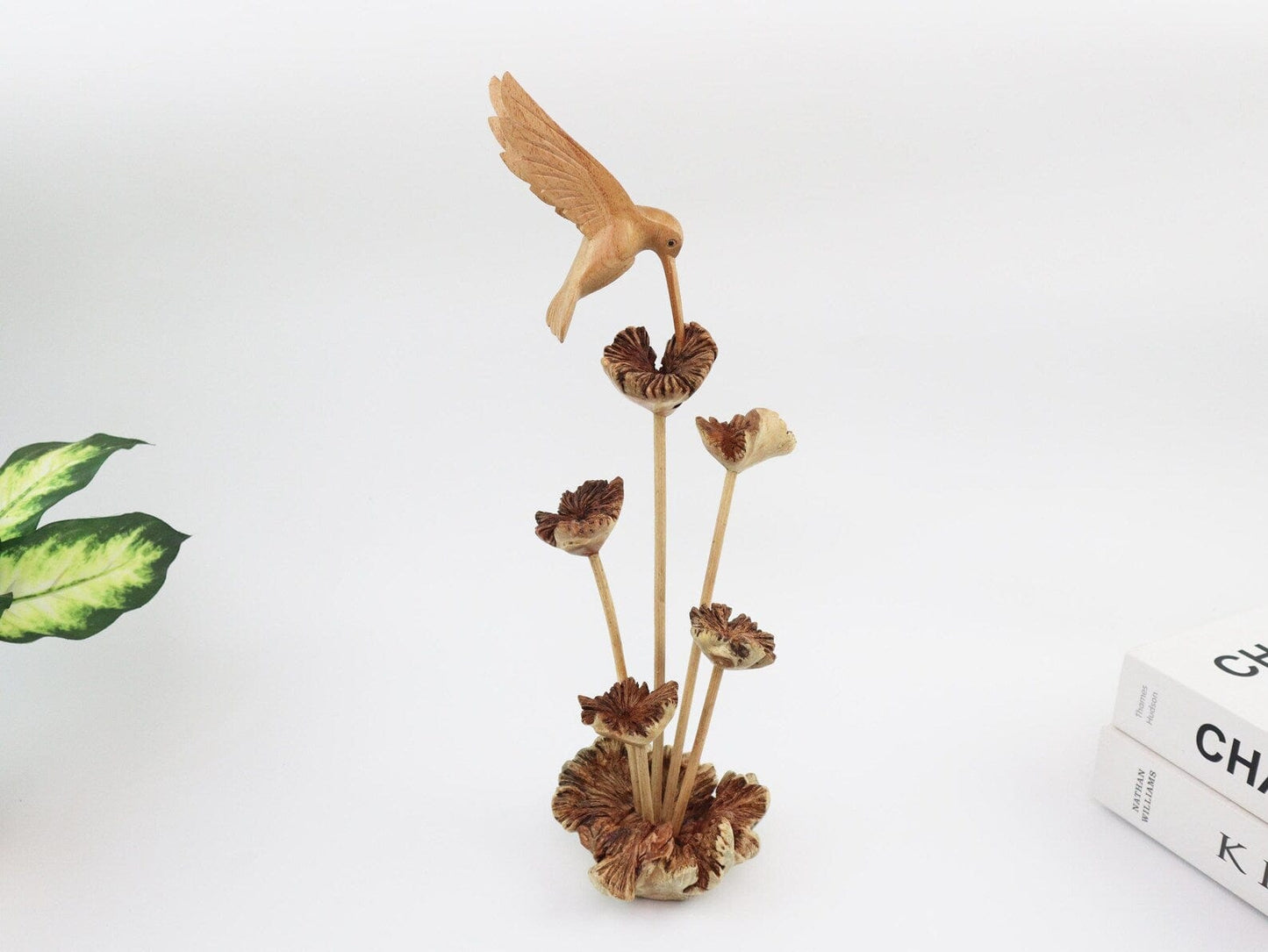 Hand-carved natural wooden tabletop sculpture featuring a single hummingbird in flight over a cluster of flowers, with a wood root base, rustic bird decor.