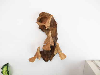 Hand-carved natural wooden wall art featuring four Canary birds interacting with a gnarled wood base, rustic bird flock decor.