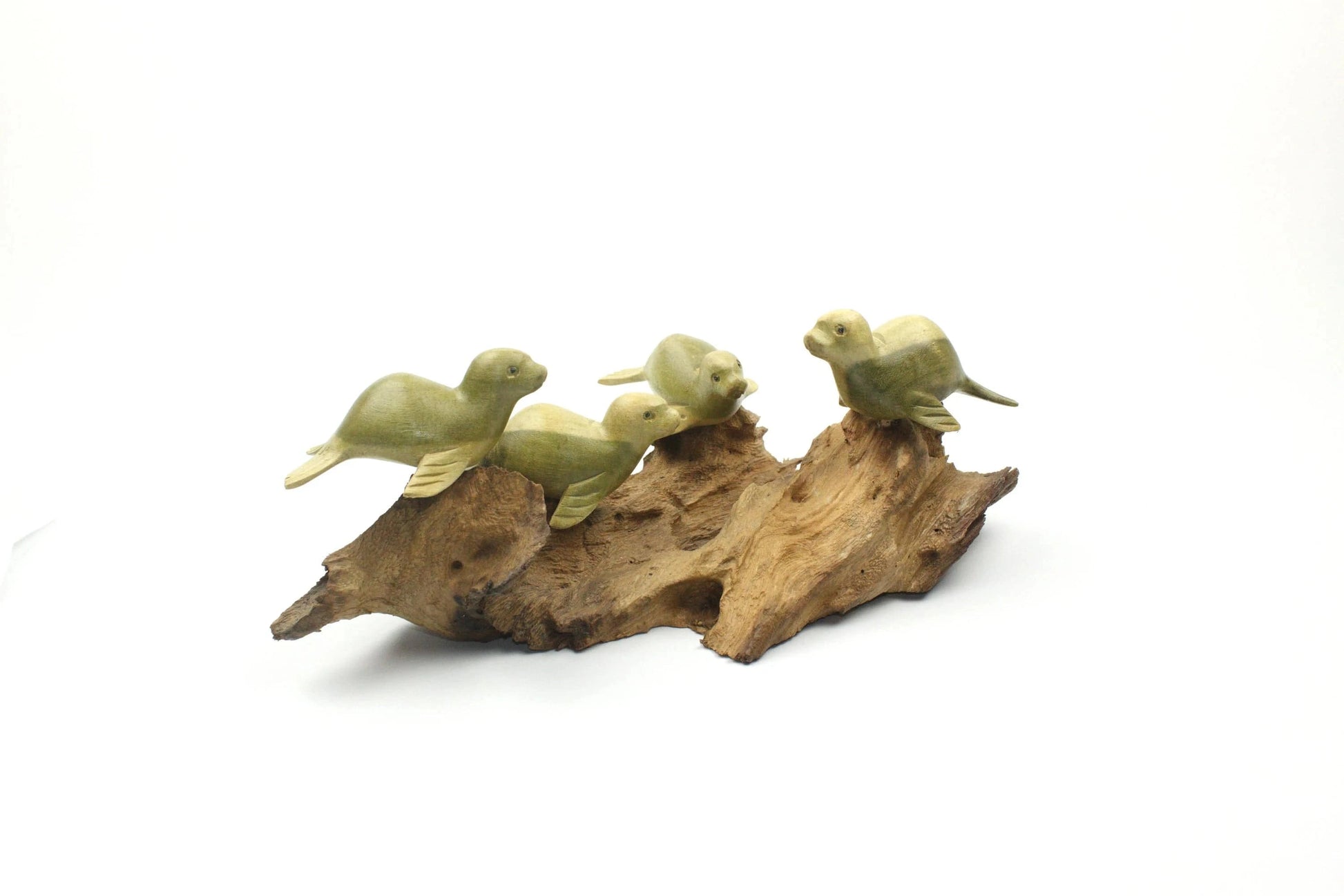 Hand-carved natural wooden sculpture featuring a group of four seals resting on a rugged driftwood base, rustic coastal decor.