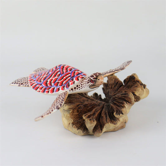 Hand-carved and painted wooden sculpture featuring a sea turtle with a red, white, and blue shell on a large, textured wood base, colorful coastal decor.