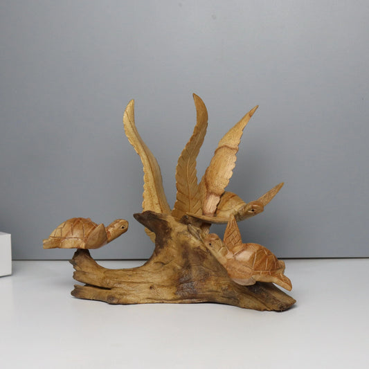 Hand-carved natural wooden sculpture featuring a family of three sea turtles on a rugged driftwood base with a central fan-like wood piece, rustic coastal decor.

