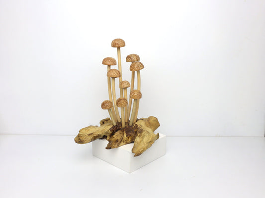 Hand-carved natural wooden sculpture featuring a cluster of slender-stemmed Enoki-style mushrooms with small, textured caps on a natural wood base, rustic tabletop decor.