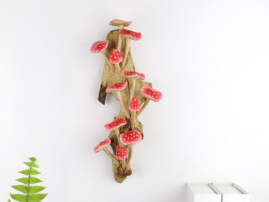 Large hand-carved natural wooden wall art featuring a dense cluster of red and white polka-dot mushrooms on a tall upright natural wood log or root, whimsical fairy tale decor.