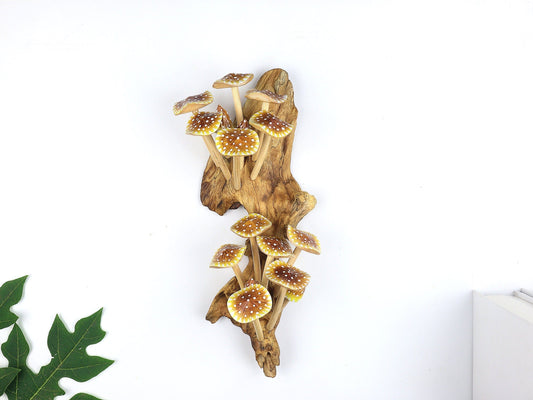Hand-carved natural wooden sculpture featuring a large cluster of yellow, orange, and brown speckled mushrooms on an upright natural wood log or root, whimsical wall art decor.