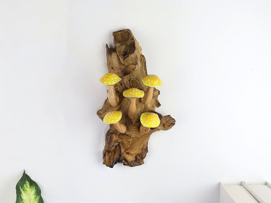 Hand-carved natural wooden wall art featuring five yellow and white polka-dot mushrooms on an upright natural wood log or root, whimsical fairy tale decor.