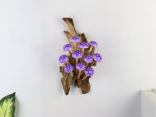 Hand-carved natural wooden sculpture featuring a large cluster of purple and white polka-dot mushrooms on an upright natural wood log or root, whimsical wall art decor.