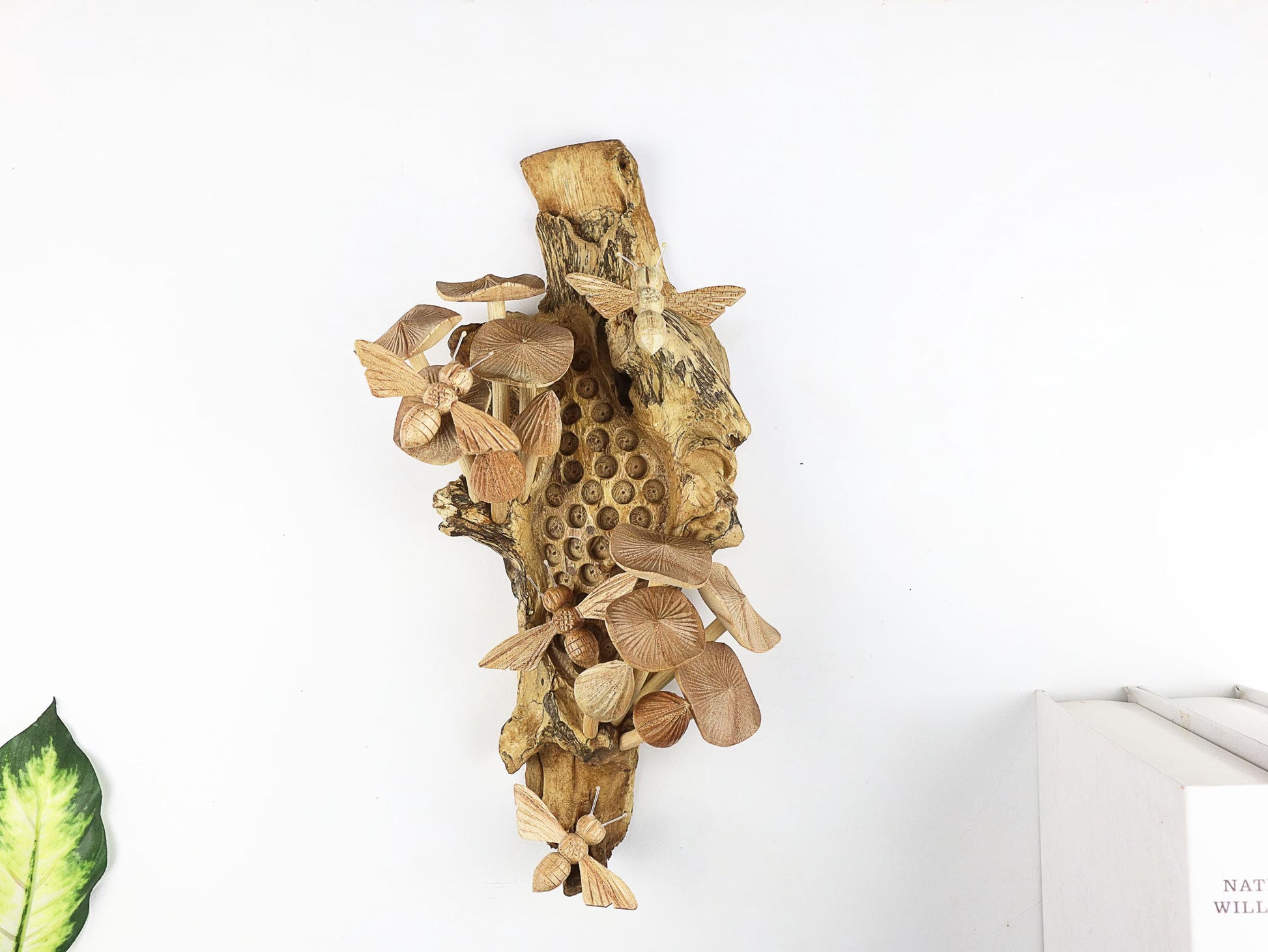 Hand-carved natural wooden wall art featuring bees and mushrooms on a carved honeycomb-like pattern on a gnarled upright wood log, rustic bee and fungus decor.

