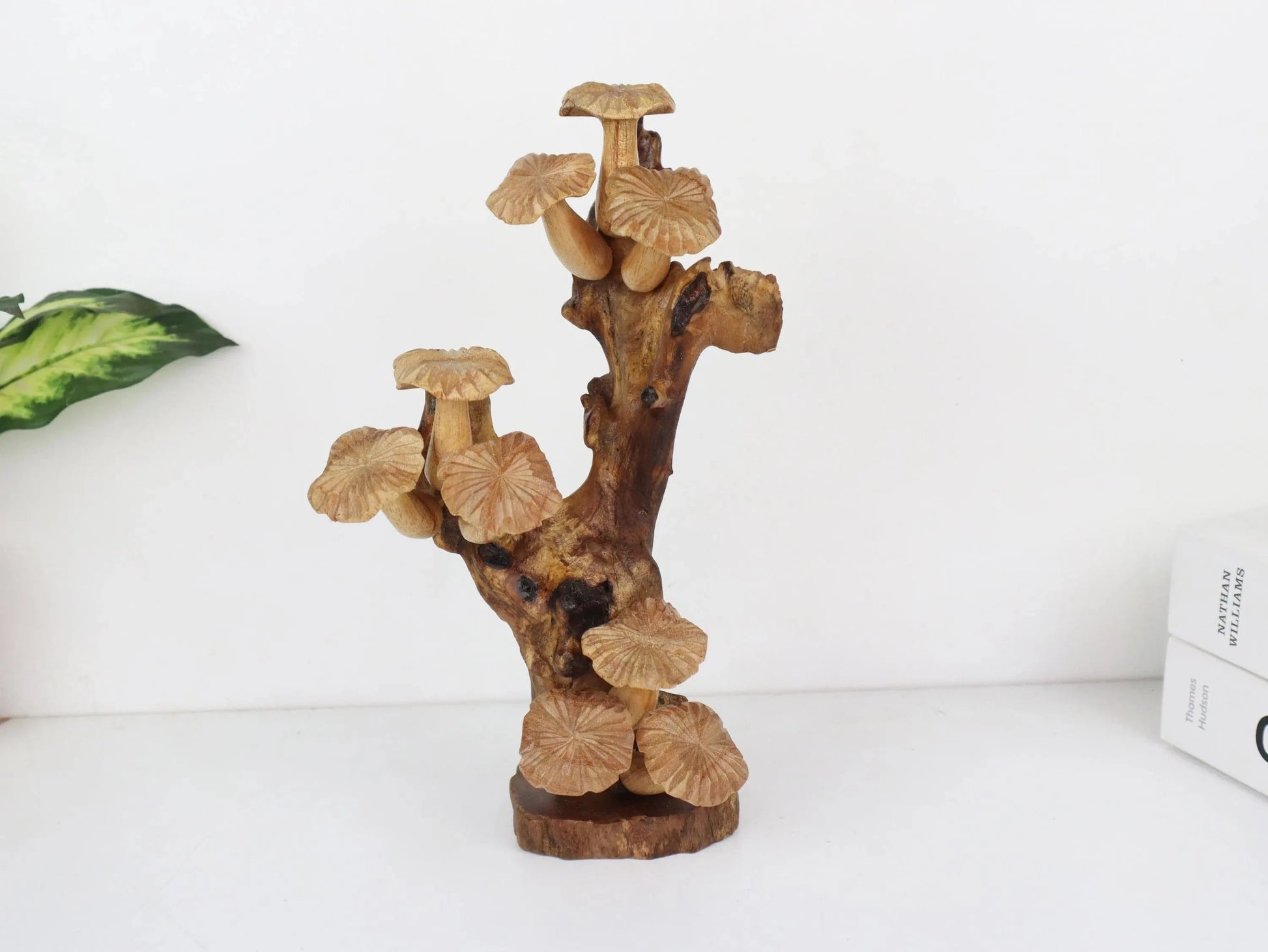 Hand-carved natural wooden sculpture featuring a dense cluster of mushrooms on an upright gnarled wood root, mounted on a round freestanding wooden base, rustic tabletop decor.