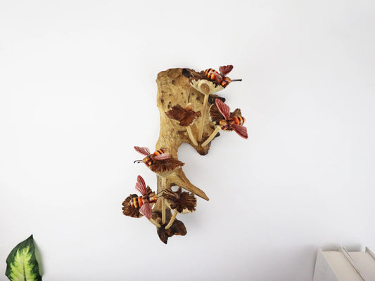 Hand-carved and painted wooden wall art featuring multiple bees interacting with natural mushrooms on an upright gnarled wood log, rustic woodland decor.