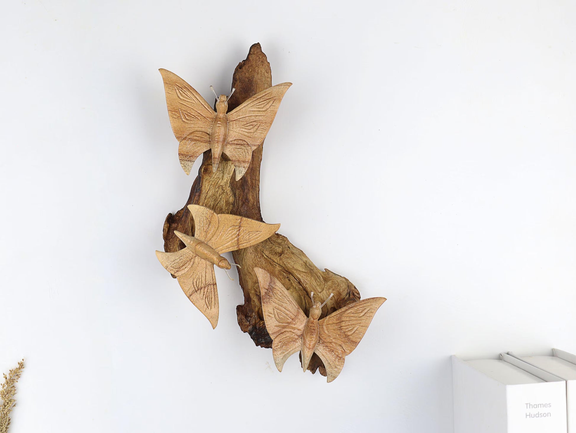 Hand-carved natural wooden wall art featuring three large butterflies fluttering vertically on a textured wood log or root, rustic woodland decor.