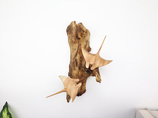 Hand-carved natural wooden wall art featuring a pair of manta rays swimming on a rugged driftwood base, rustic coastal decor.