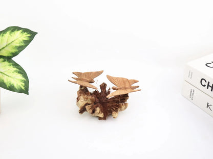 Hand-carved natural wooden sculpture featuring a pair of butterflies facing each other on a gnarled horizontal wood piece, rustic tabletop decor.