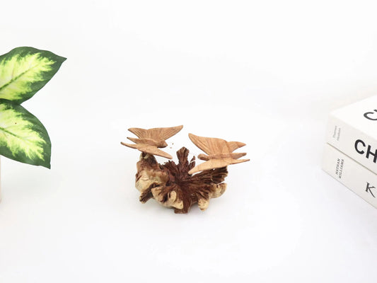 Hand-carved natural wooden sculpture featuring a pair of butterflies facing each other on a gnarled horizontal wood piece, rustic tabletop decor.
