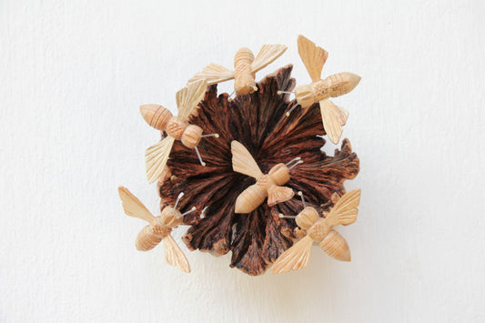 Hand-carved natural wooden wall hanging featuring multiple bees swarming around a stylized flower, rustic floral decor.